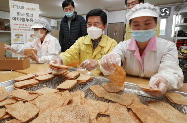 (사진제공=동구)황인호 동구청장(가운데)이 자활참여자와 누룽지 제조에 참여 하고 있다