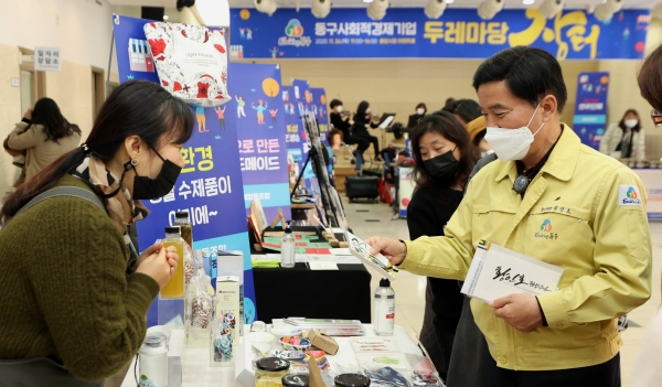 황인호 동구청장이 사회적경제 기업 물품을 보고 있다.