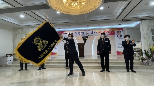 ▲위 사진: 민경찬 회장이 직전회장으로부터 정기를 전달받고 흔들고 있다