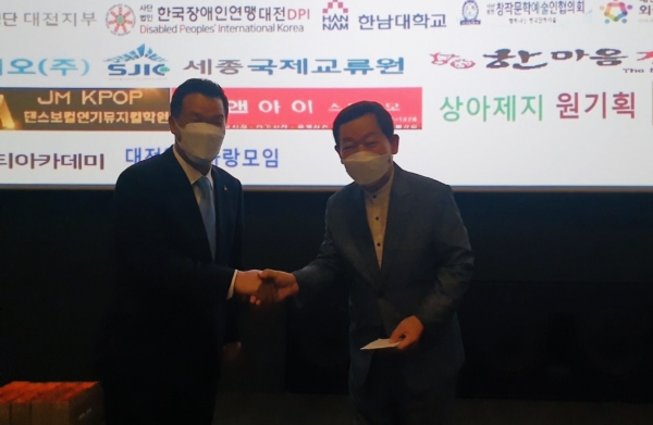 위 사진: 8월 사랑나누기 영화산책 후원금을 부야주식회사 형석윤 대표(좌)가 대전영화인협회 성낙원 회장(우)에게 전달하고 있다.
